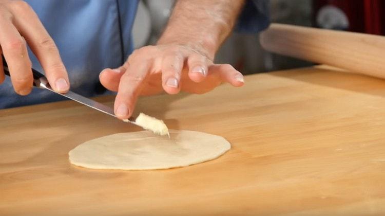 Norėdami samsa su moliūgu, pirmiausia uždėkite sviesto gabalėlį ant tortilijų.