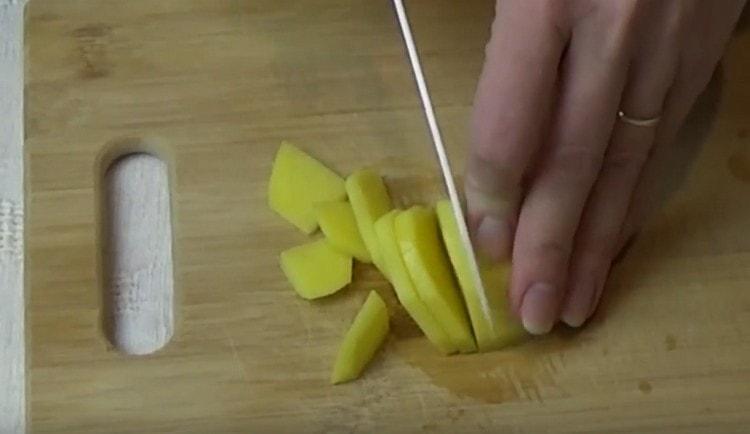 Oloupejte a nasekejte brambory.