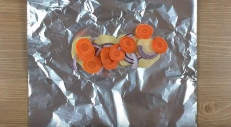 mettere le patate su un foglio, aggiungere sopra cipolle e carote.