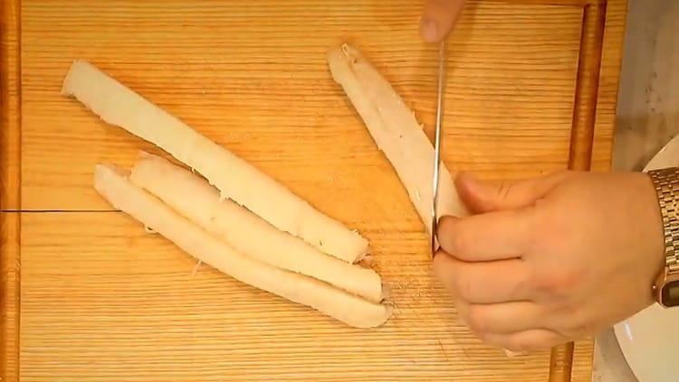 Filetto di merluzzo tagliato a strisce lunghe, ognuna delle quali è tagliata a metà obliquamente.