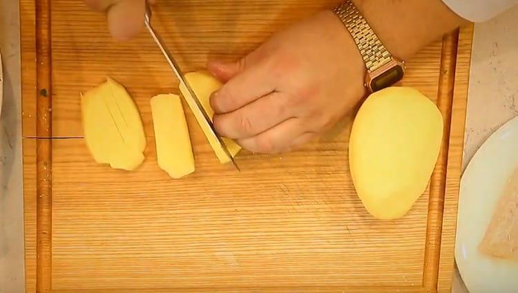 Tagliare le patate per cucinare le patatine.