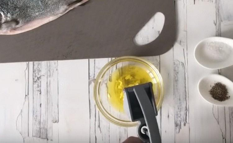 Olívaolajban nyomja meg a fokhagymát egy sajtolón keresztül.