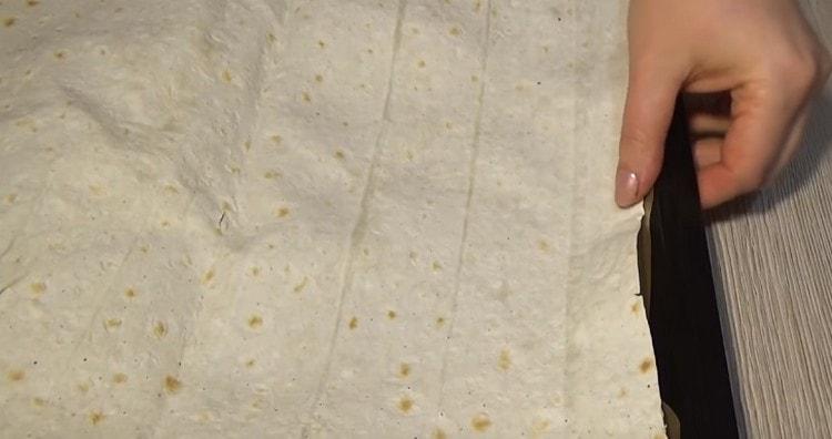 Σε ένα φύλλο περγαμηνής που έχει λιπαρώσει με φυτικό λάδι σε ένα φύλλο ψησίματος τοποθετούμε ένα φύλλο ψωμιού πίτας.