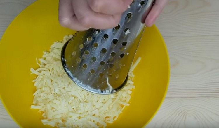 Grattugiate il formaggio suluguni su una grattugia.
