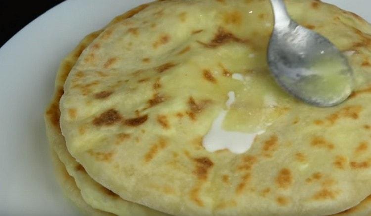 Fertiges Khachapuri wird normalerweise mit geschmolzener Butter eingefettet.