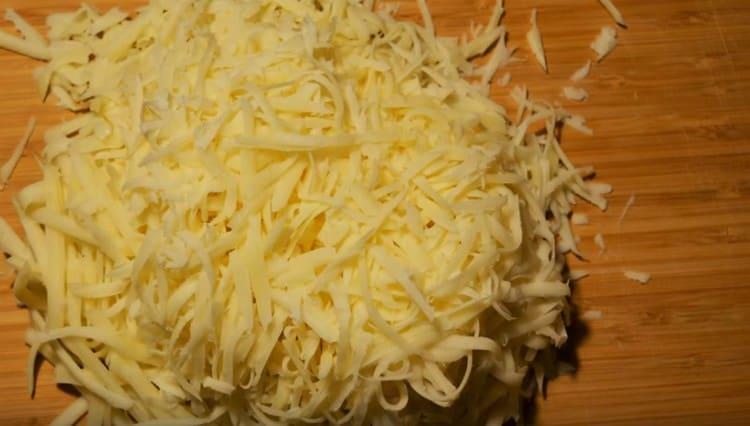 Suluguni-Käse auf einer Reibe reiben.