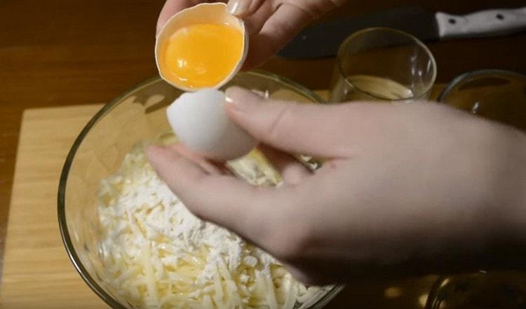 Добавете сол, яйчен белтък, вода към сиренето.