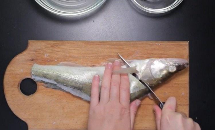 دون قطع حتى النهاية ، نفصل رأس السمكة عن الجسم.