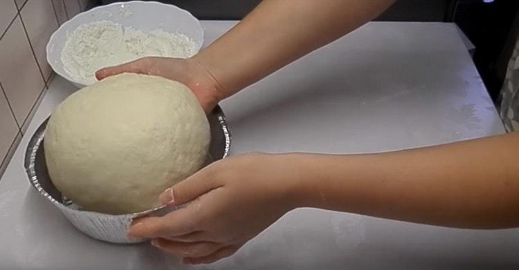 Έχοντας σχηματίσει στρογγυλό ψωμί, το βάζουμε σε λιπαρή μορφή με φυτικό έλαιο.