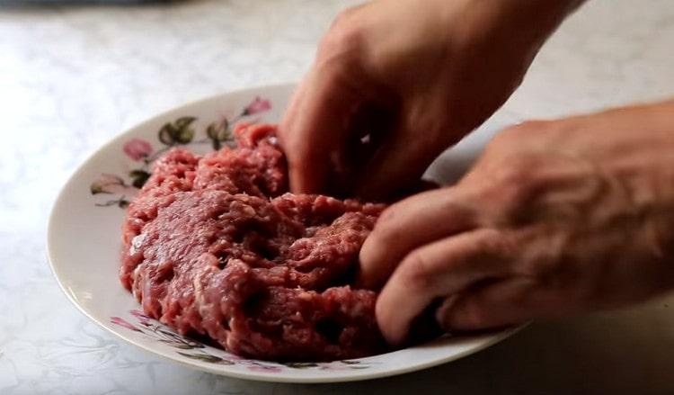 Добавете сол и черен пипер към месото на вкус и разбъркайте.