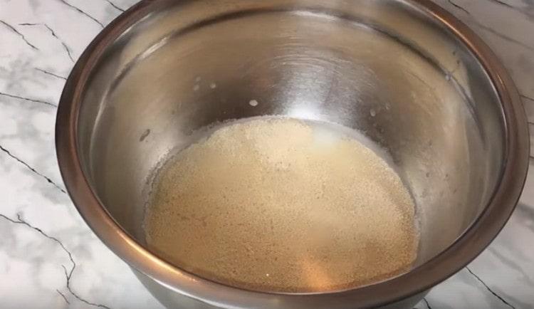 Διαλύουμε ζύμη με ζάχαρη σε ζεστό νερό.