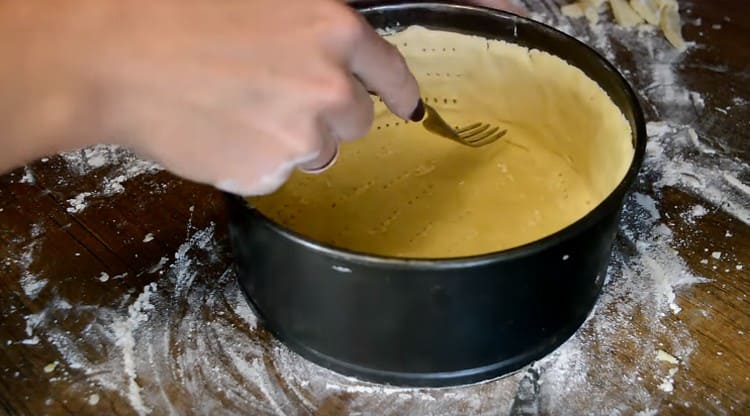 Con una forchetta, pungiamo sia il fondo che i lati della base per la cheesecake.