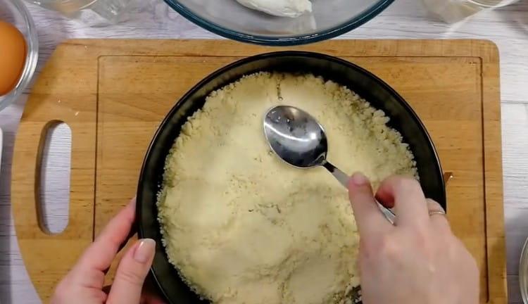 Έχοντας ανακατεύουμε αλεύρι με ζάχαρη και βούτυρο, δημιουργούμε τη βάση για το cheesecake από αυτή τη μάζα.