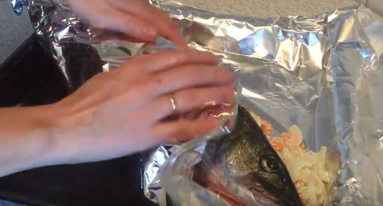 Прехвърлете рибата в зеленчукова подложка и внимателно увийте във фолио.