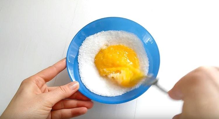Докато млякото кипи, смилайте жълтъците със захарта.