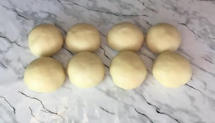 Per preparare i panini al lievito alla crema, dividere l'impasto