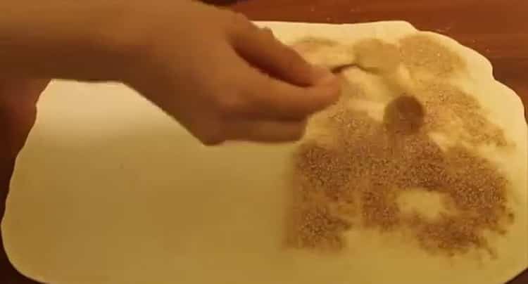 Geben Sie Zucker auf den Teig, um Brötchen zu machen