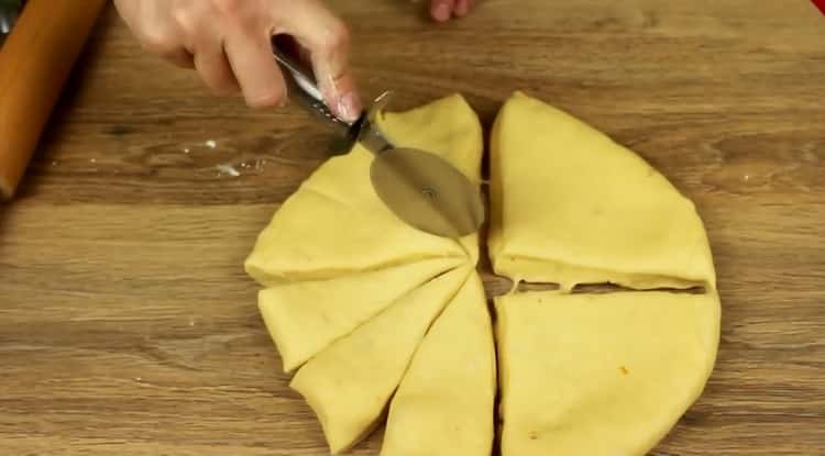 Για να κάνετε κουλουράκια με τυρί cottage από ζύμη ζύμης, διαιρέστε τη ζύμη