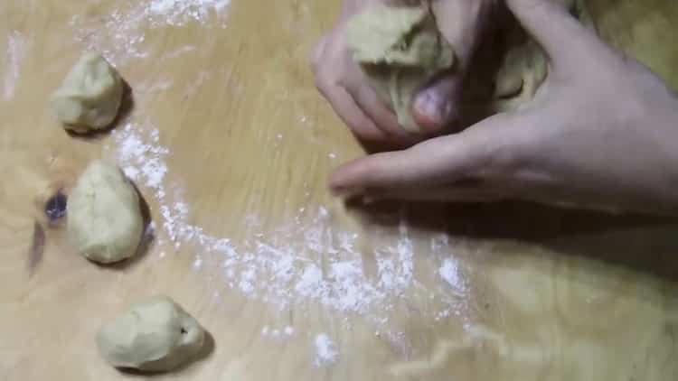 Um aus Hefeteig Brötchen mit Zucker zu machen, teilen Sie den Teig