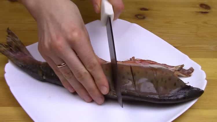 За да готвите цяла розова сьомга във фурната, направете разрези в рибата