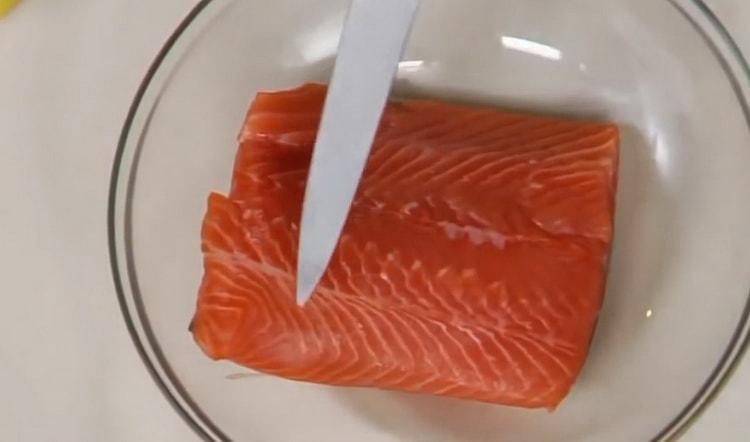 Norėdami virti raudoną žuvį orkaitėje, supjaustykite žuvį