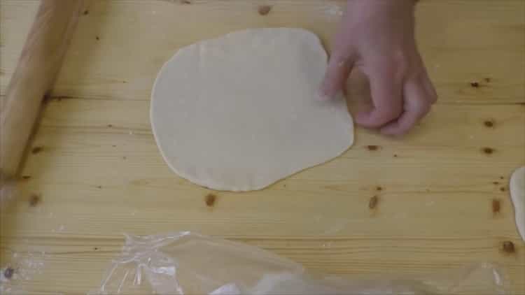 Für Croissants mit Kondensmilch den Teig ausrollen