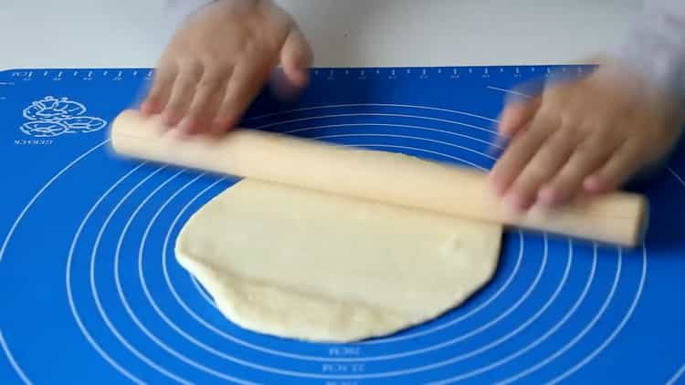 Разточете тестото, за да направите брашни тортили в тиган