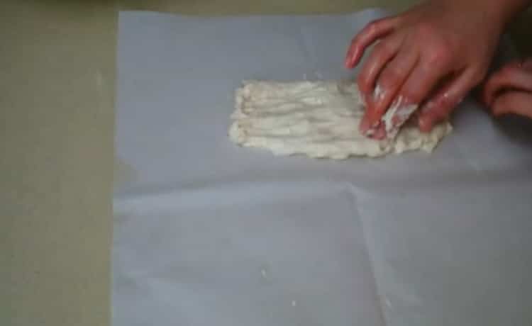 Für die Zubereitung von Kuchen auf Kefir den Teig auf Pergament legen