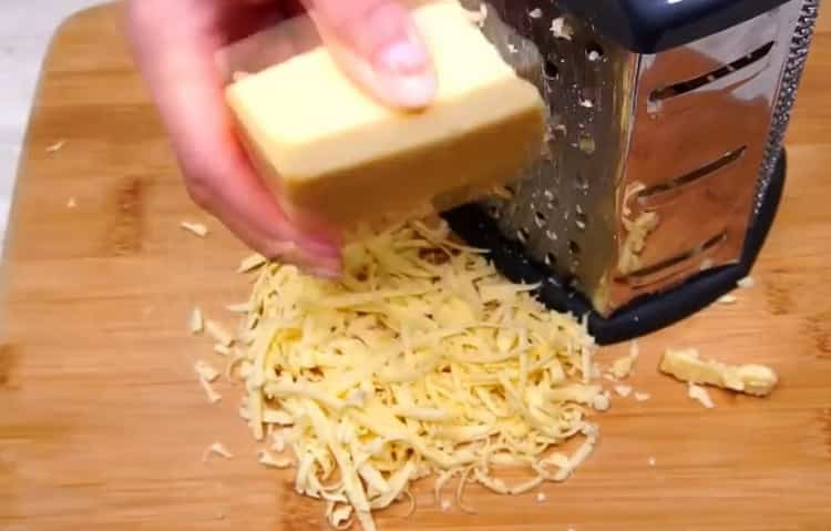Reiben Sie die Zutaten, um Käsekuchen im Ofen zuzubereiten