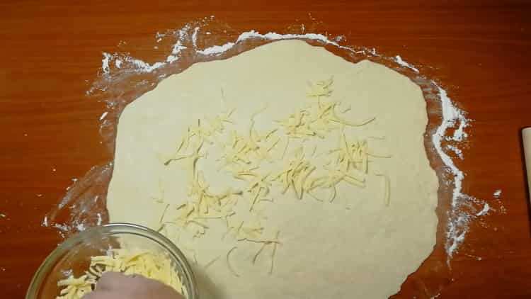 Geben Sie Käse auf den Teig, um Käsekuchen zuzubereiten