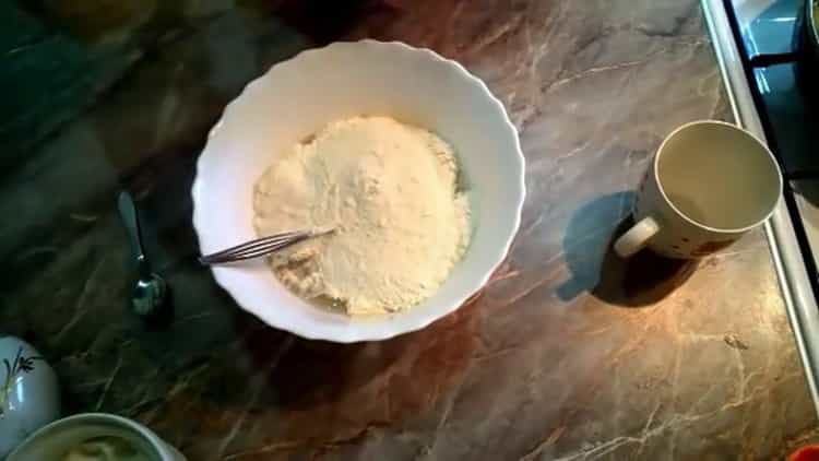 Setacciare la farina per cuocere le torte uzbeke nel forno
