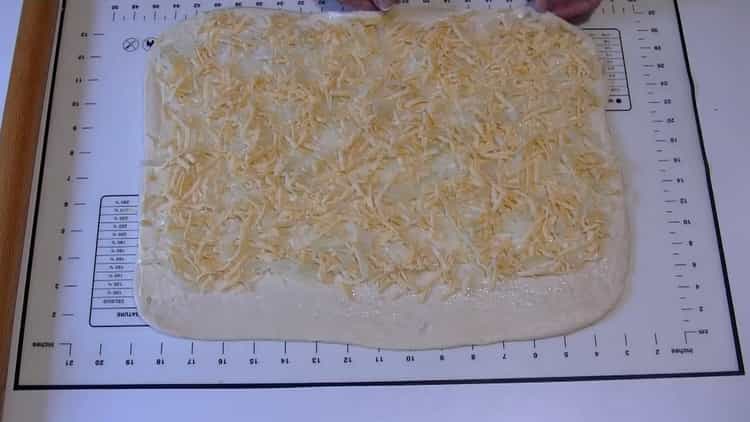 Για να προετοιμάσετε κέικ κρεμμυδιού, βάλτε τη γέμιση στη ζύμη