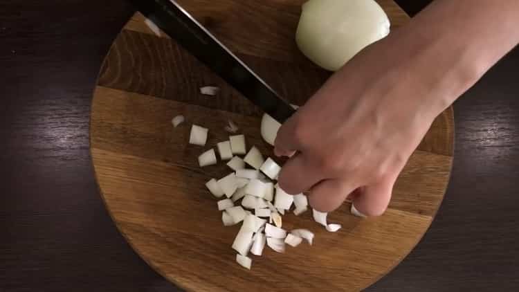Zwiebel hacken, um Nudeln zu kochen