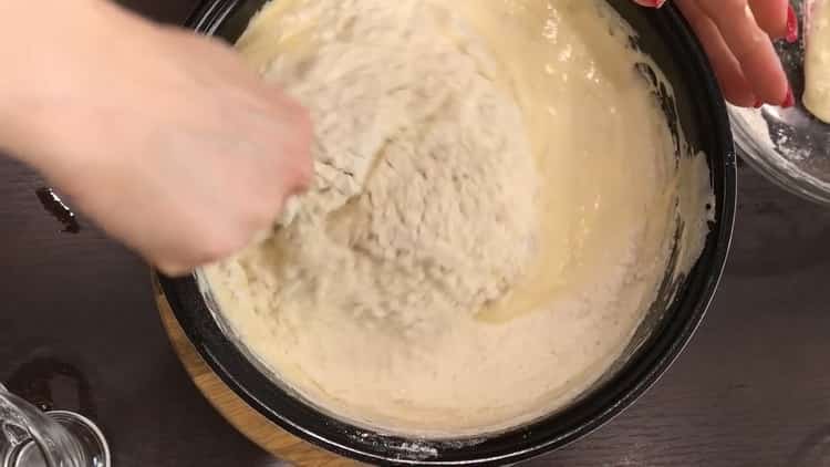 Sieben Sie das Mehl, um einen Schokoladenkuchen zu machen