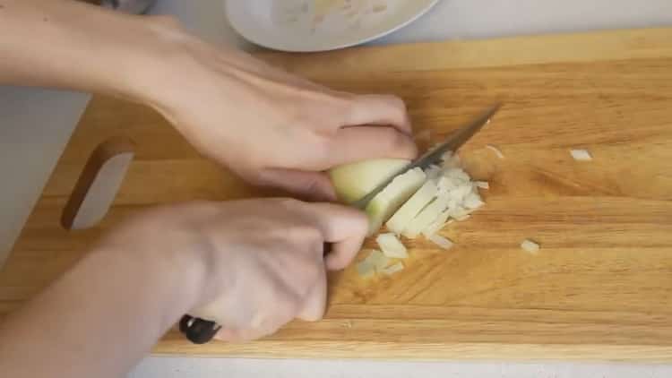Per cucinare il pollock, tritare la cipolla