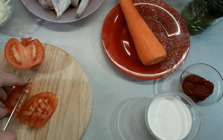 За да сготвите минтая в сметанов сос, нарежете доматите