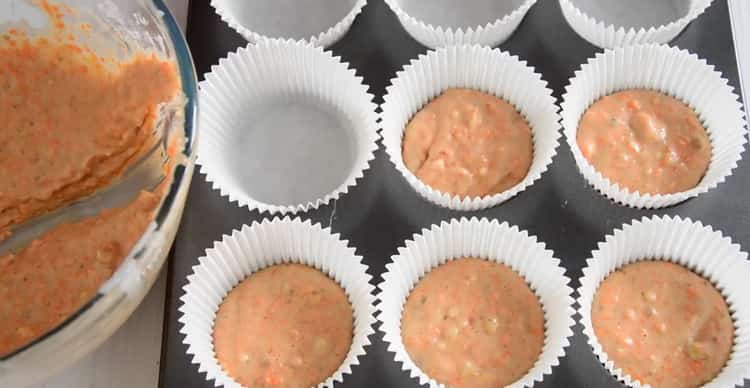 Leckere Karottencupcakes mit Frischkäse, den Teig in die Form geben