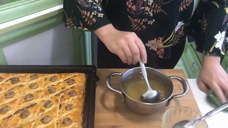 Um Baklava aus Blätterteig zuzubereiten, gießen Sie das Dessert mit Sirup ein