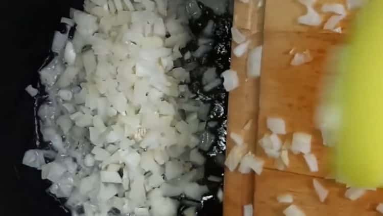 Запържете лука, за да направите оризови пайове