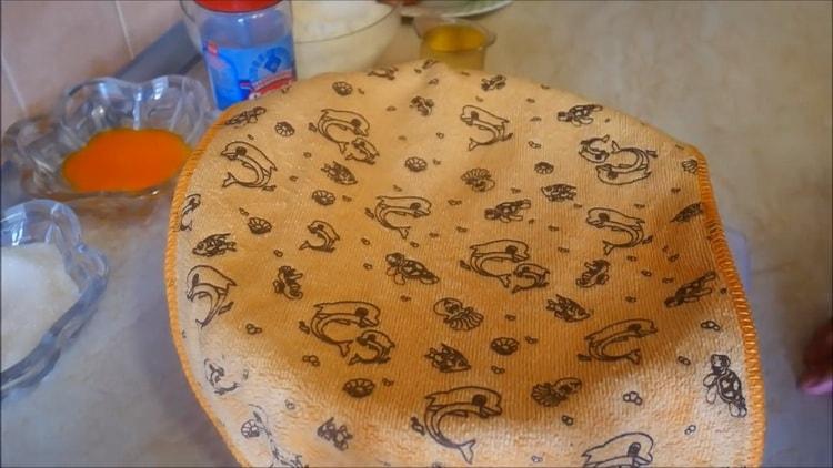 Um Apfelkuchen im Ofen zuzubereiten, bedecken Sie den Teig mit einem Handtuch