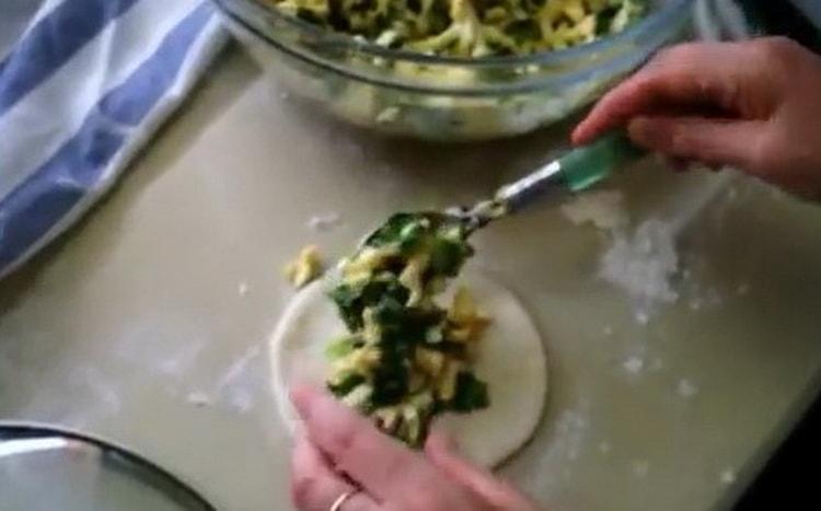 Tojással és zöld hagymával pite készítéséhez tegye a tölteléket a tésztára