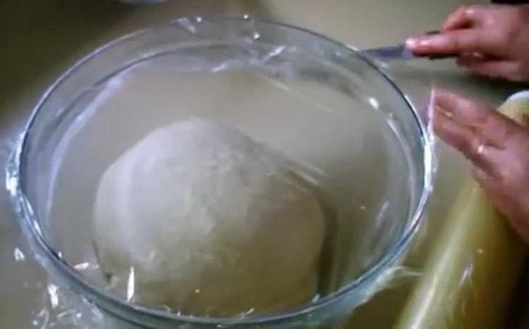 За да направите пайове с яйца и зелен лук, поставете тестото под филм