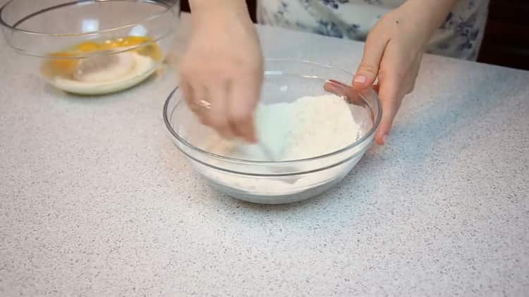 Sieben Sie das Mehl, um einen einfachen Kuchen zuzubereiten