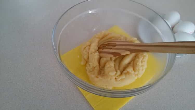 Fügen Sie dem Teig Eier hinzu, um Kränzchen mit Vanillesoße zu machen