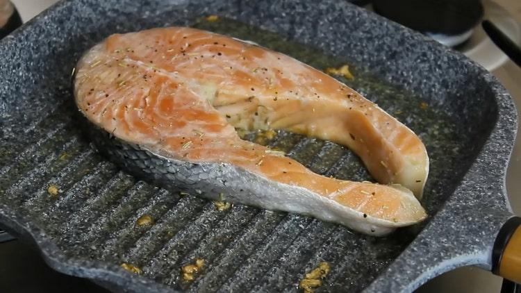 Braten Sie den Fisch in einer Pfanne, um Lachssteak zuzubereiten