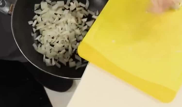 Per preparare la salsa di spaghetti al pomodoro, tritare la cipolla