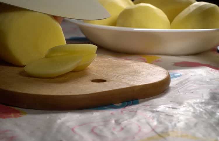 Um Kabeljau mit Kartoffeln im Ofen zuzubereiten, hacken Sie die Kartoffeln