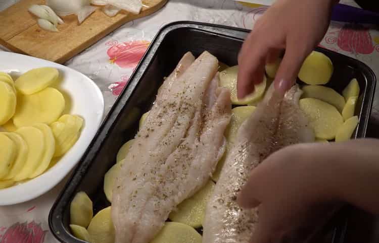 ضعي السمك على البطاطس لطهي سمك القد مع البطاطس في الفرن
