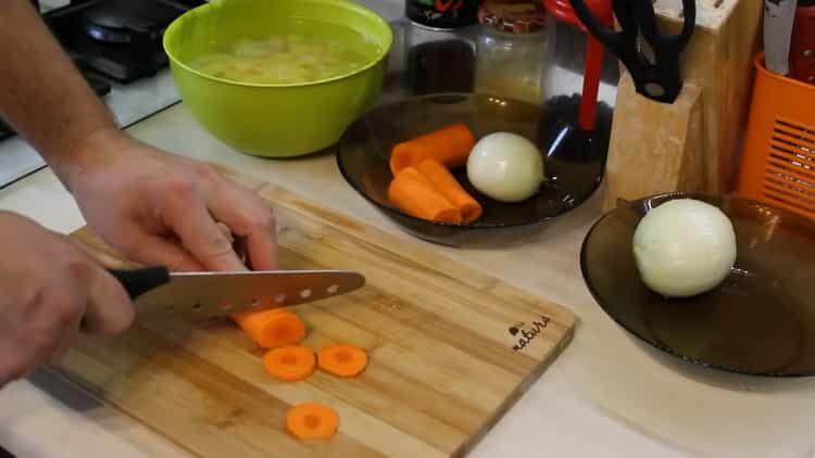 Per preparare la zuppa di salmone, tagliare la cipolla
