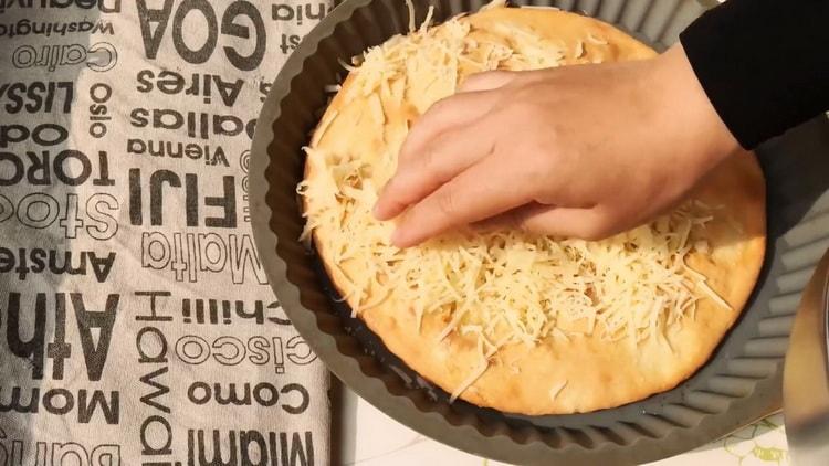 Um Khachapuri zuzubereiten, legen Sie geriebenen Käse auf ein Backblech